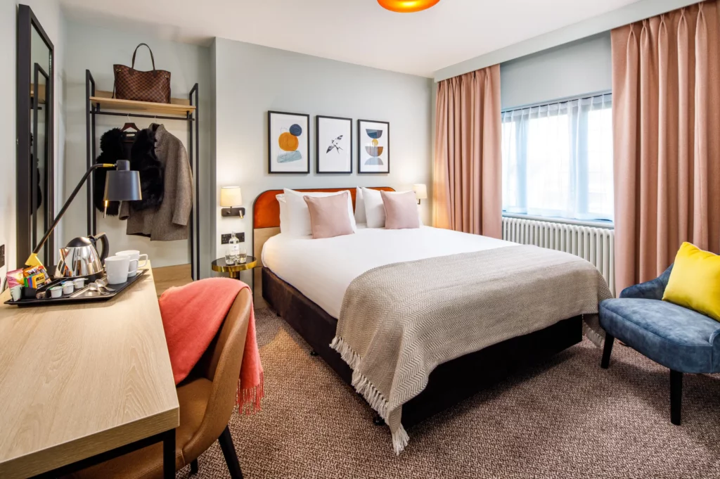 Guest bedroom at Lythe Hill Hotel with double bed and elegant furnishings