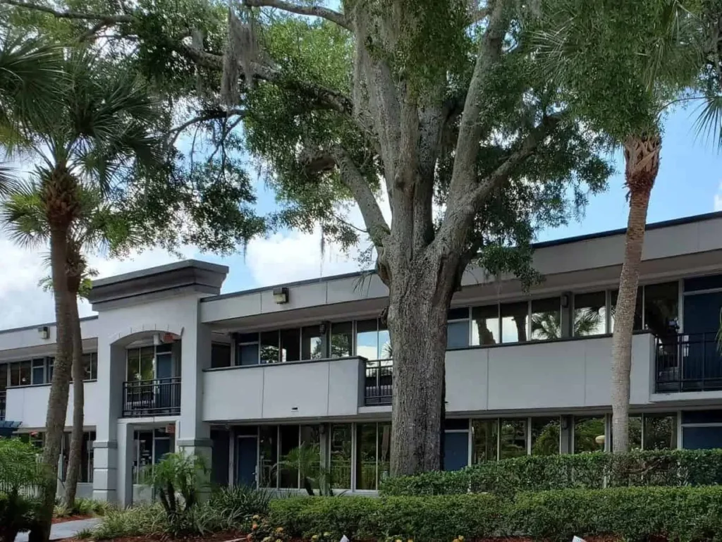 Exterior photo of Maingate Village multifamily complex with landscaped entrance